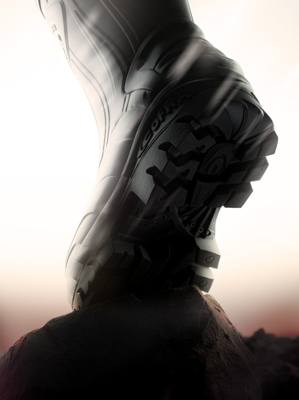 Cofra work boot on a rock against a bright backlight