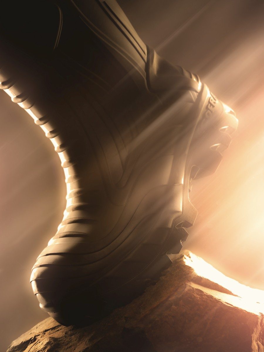 Cofra work boot on a rock, lit with warm golden backlight