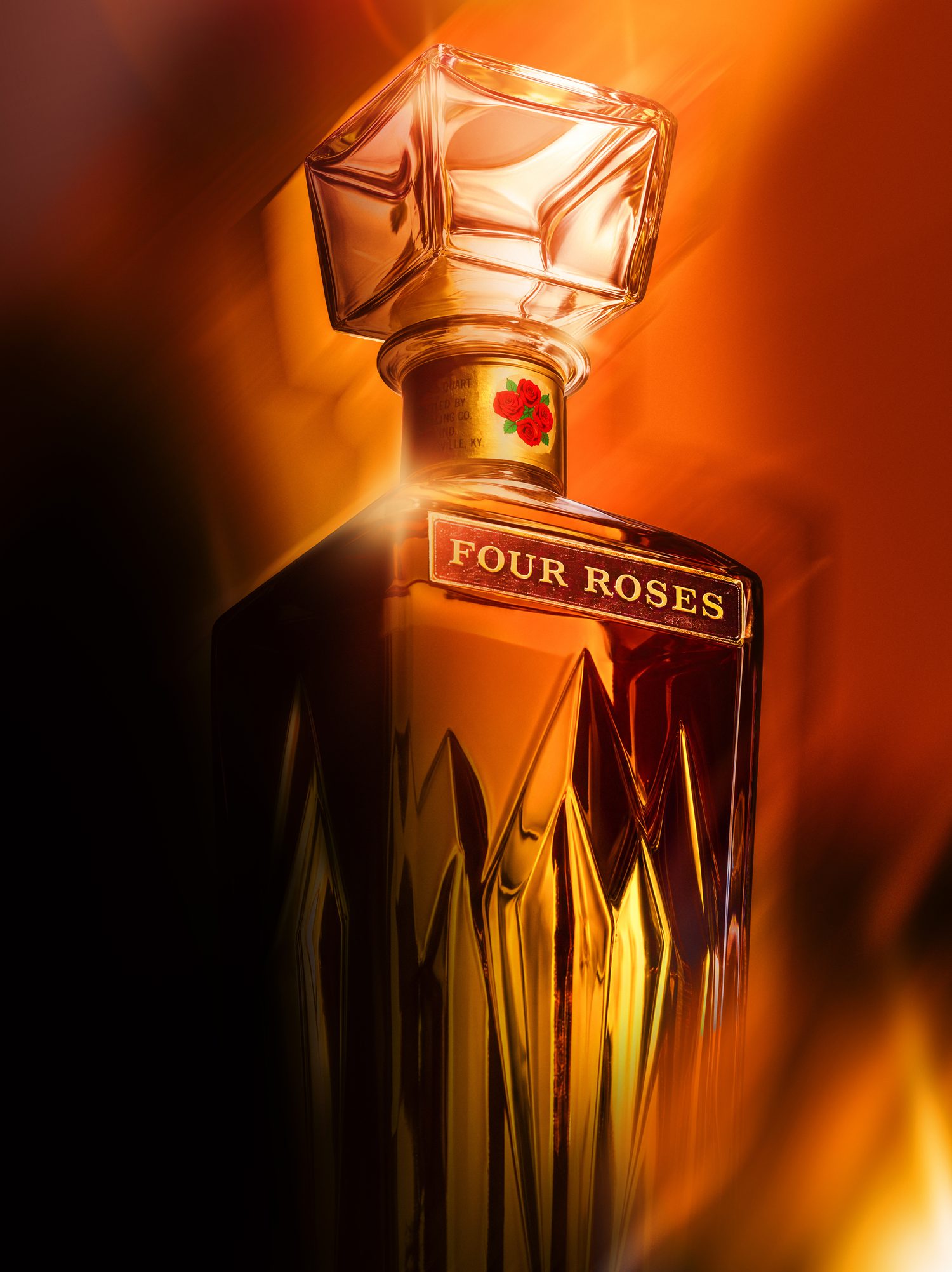 Four Roses bourbon decanter glowing amber against a fiery orange background